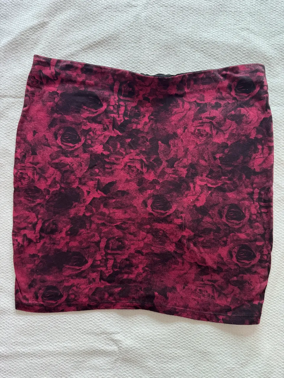 Pollera corta estampada con flores rojas y negras.