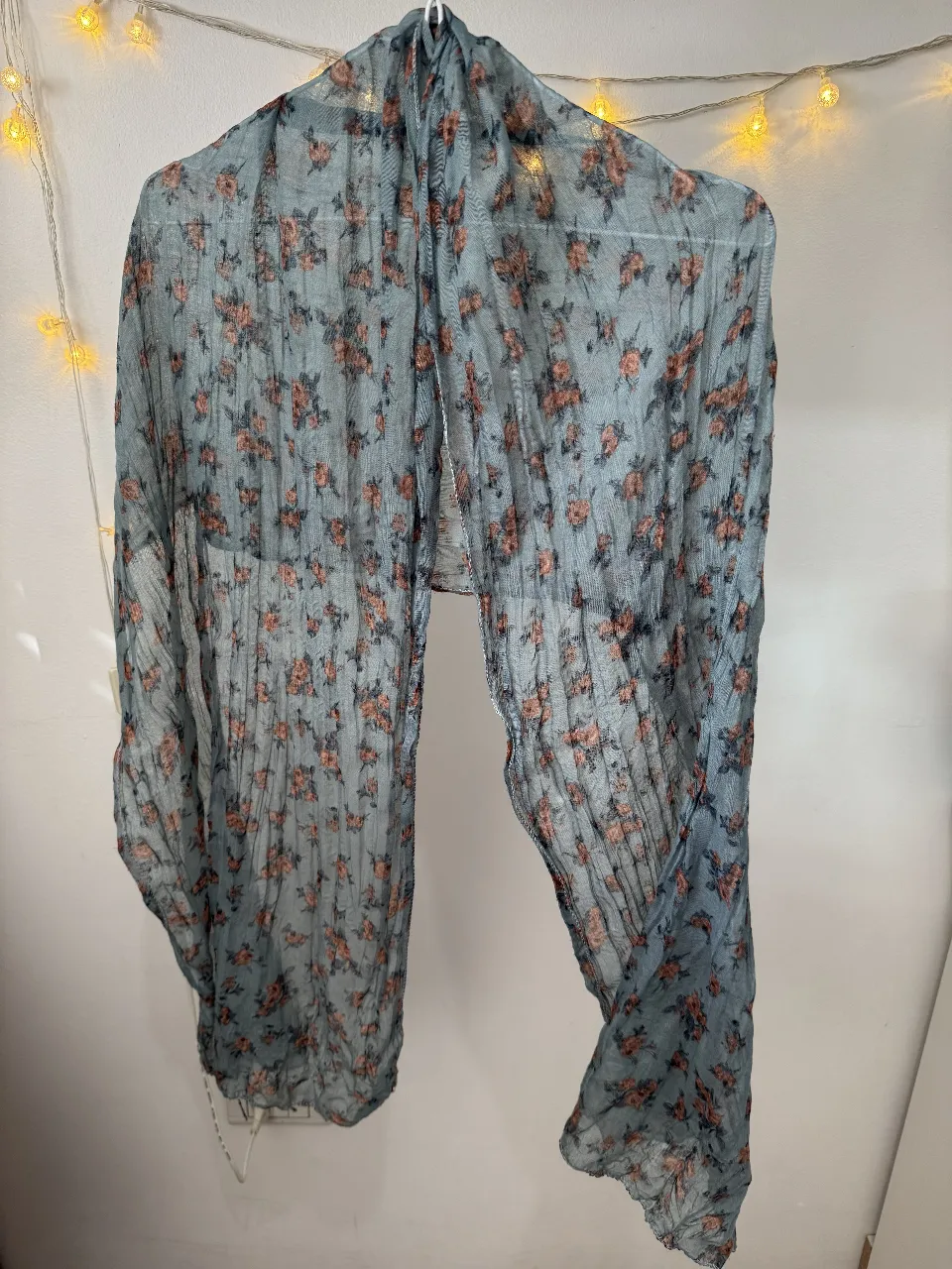 Pañuelo de gasa con estampado floral en tonos celeste y rosa. Ideal para complementar cualquier look, ligero y fresco.