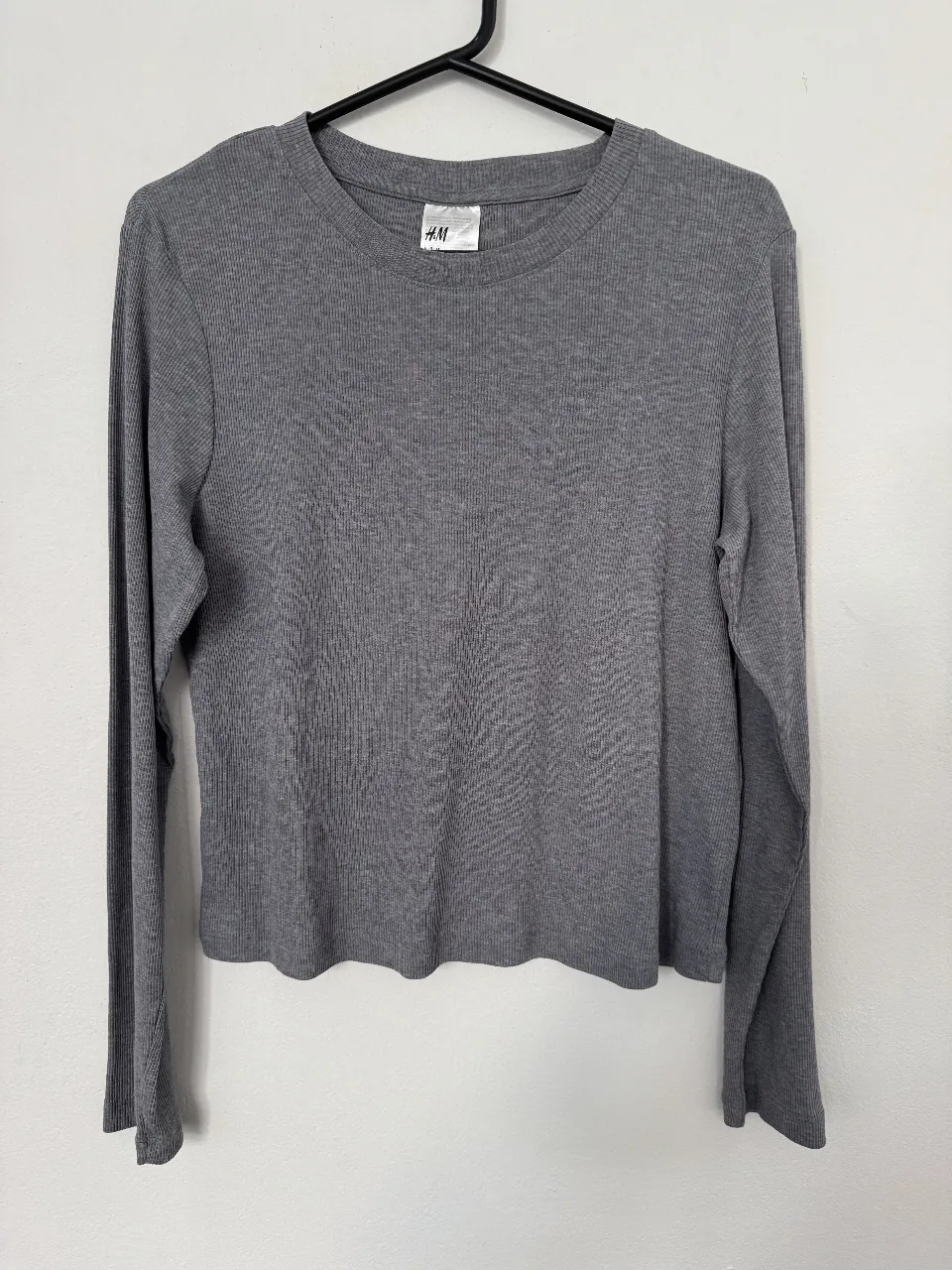 Remera de manga larga gris de H&M, ideal para un look casual y cómodo. Talle M.