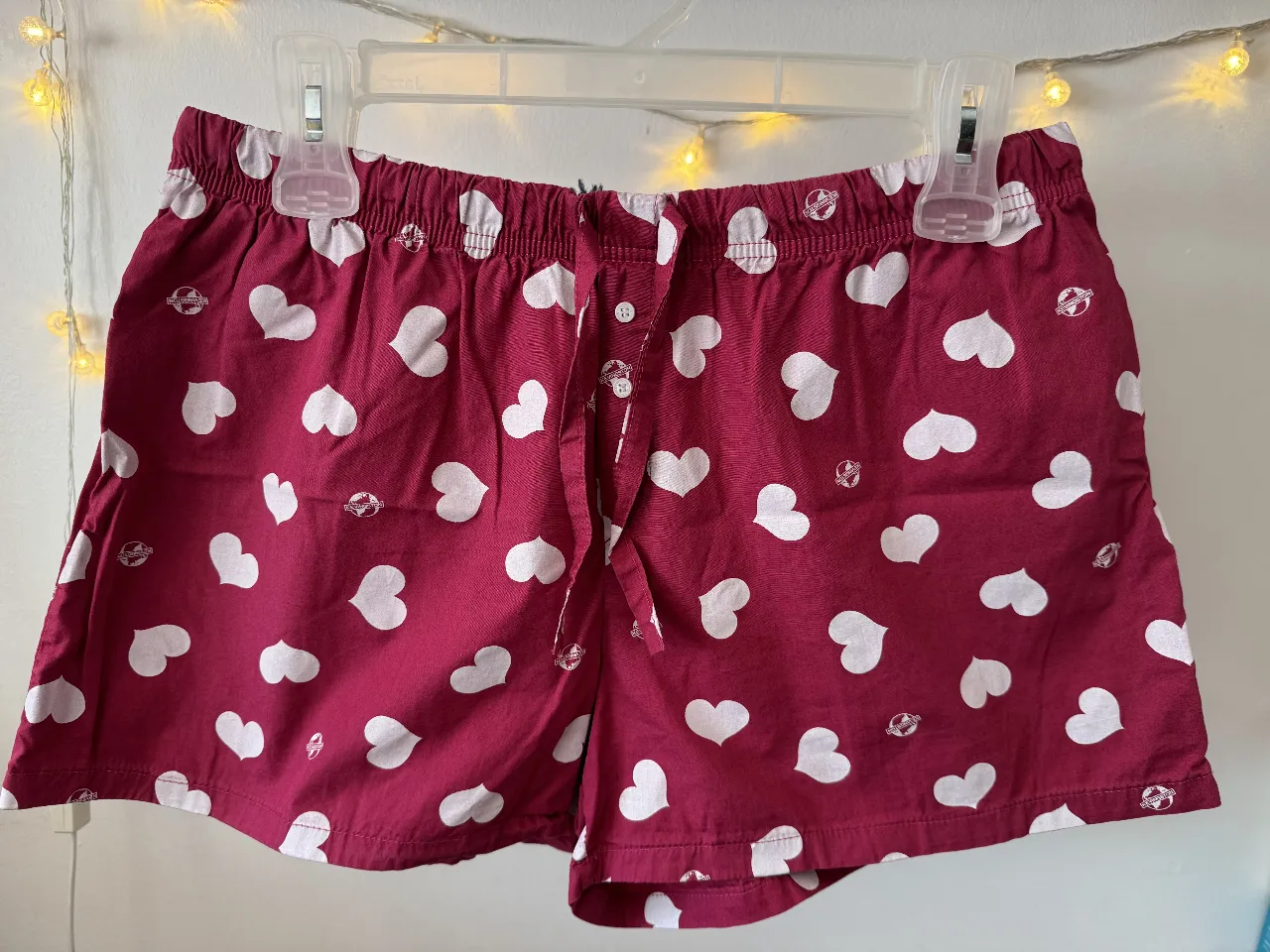 Short de pijama de mujer, color rojo con estampado de corazones blancos. Cuenta con cintura elastizada y cordón para ajustar. Ideal para estar cómoda en casa.