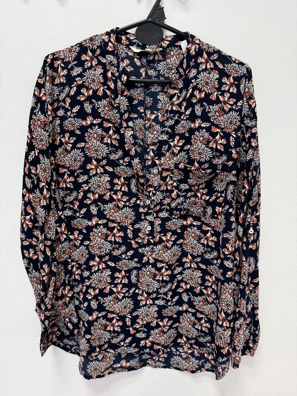 Blusa de mujer con estampado floral en tonos azul marino, blanco y marrón. Manga larga y cuello en V. Ideal para un look casual y elegante.