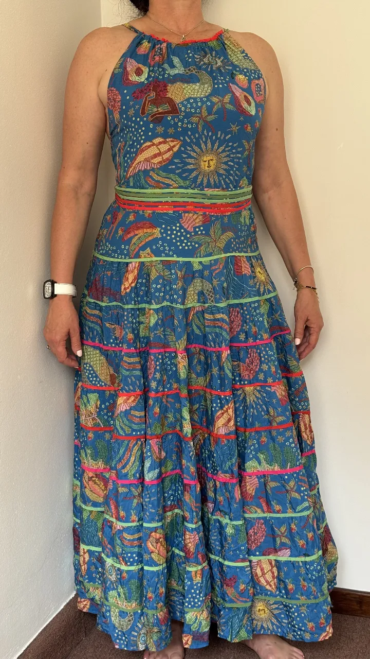 Vestido largo estampado, ideal para el verano. Posee breteles finos que se cruzan en la espalda y un lazo para ajustar. La falda es voluminosa y con varios volados, dándole un movimiento espectacular.
