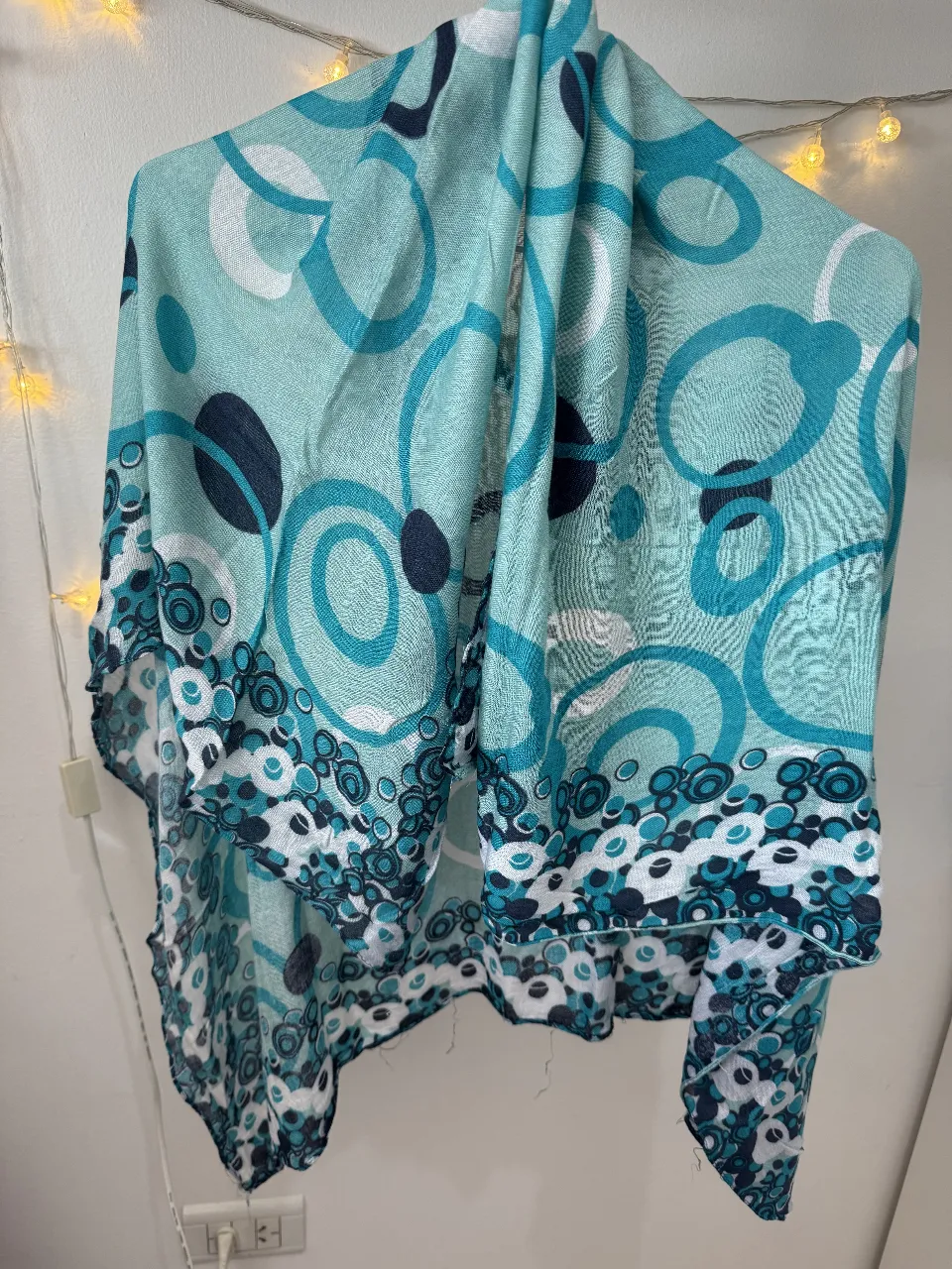 Pañuelo de tela con estampado de círculos en tonos celeste y azul. Ideal para complementar cualquier look, con un diseño moderno y versátil.