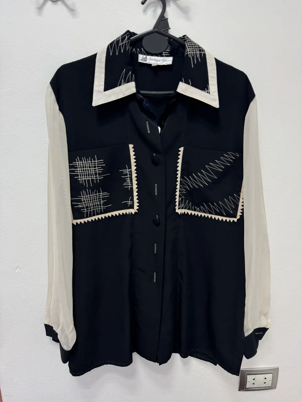 Blusa vintage de Andrea Dory, con mangas y detalles en blanco. Diseño con bolsillos y botones. Ideal para un look elegante y retro.