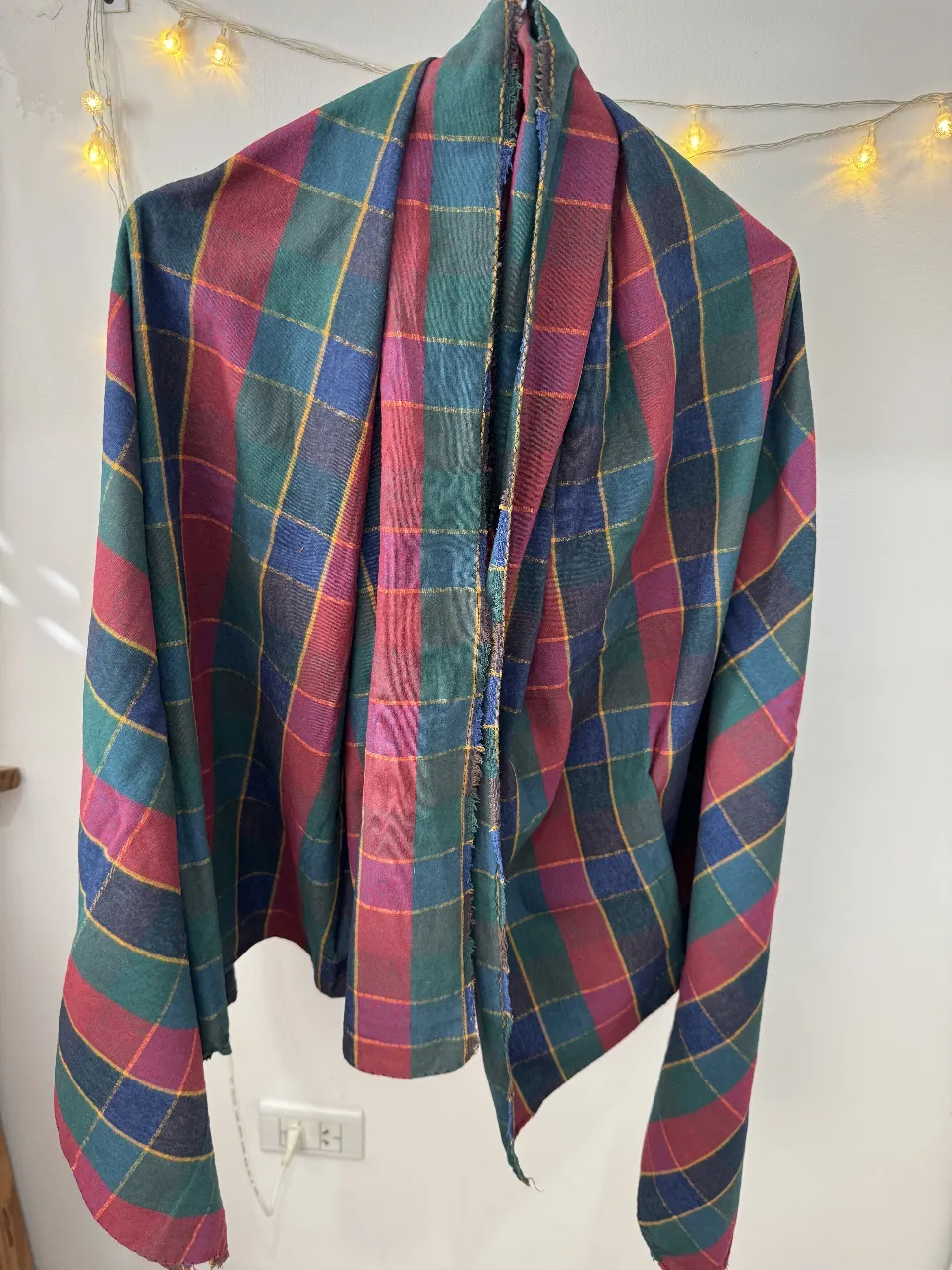 Bufanda a cuadros en tonos rojos, verdes, azules y amarillos. Ideal para abrigarte con estilo en otoño e invierno. Un accesorio versátil y con onda para cualquier look.