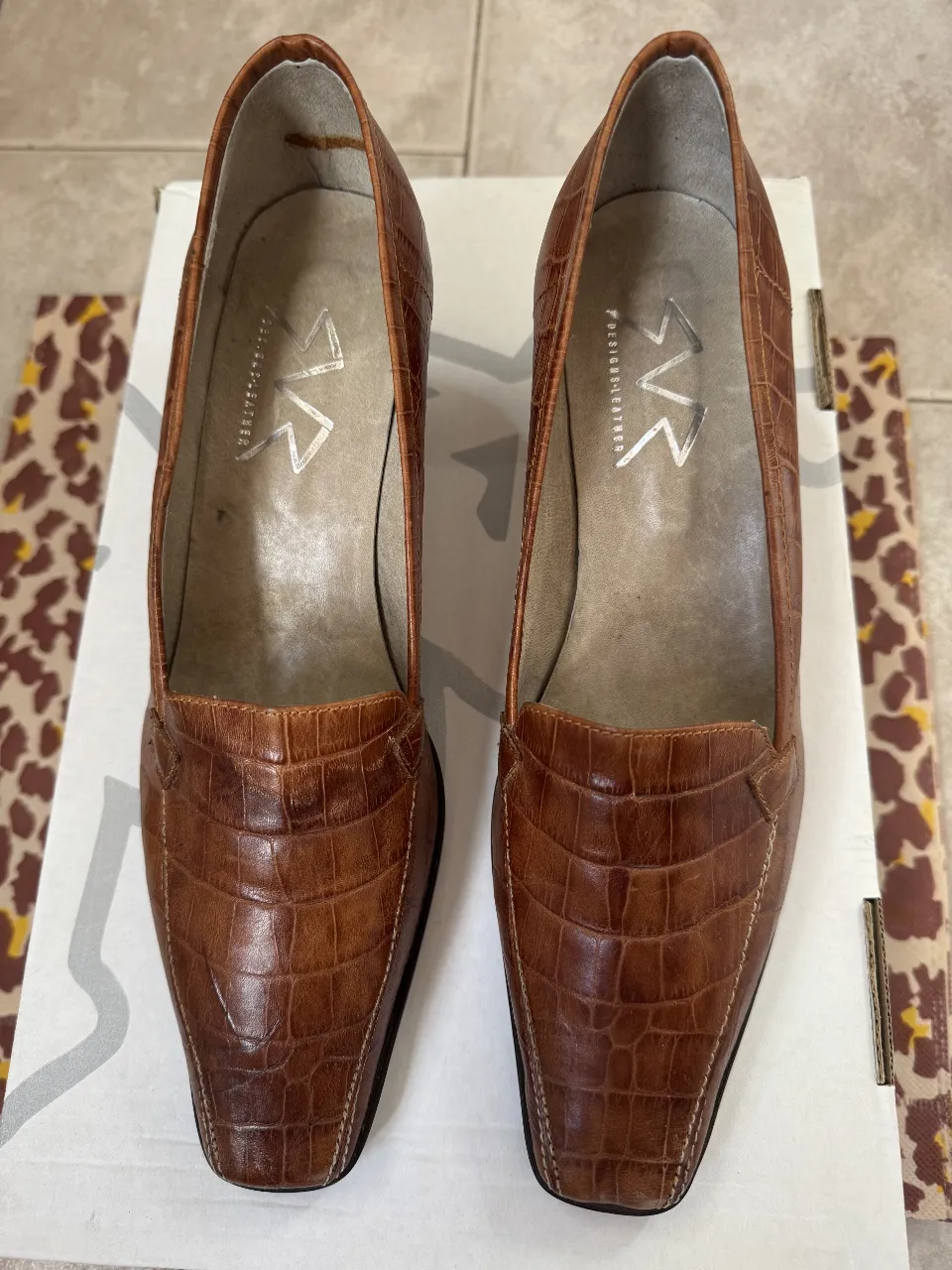 Zapatos de taco alto de cuero marrón con diseño de reptil. Ideales para un look elegante y sofisticado.