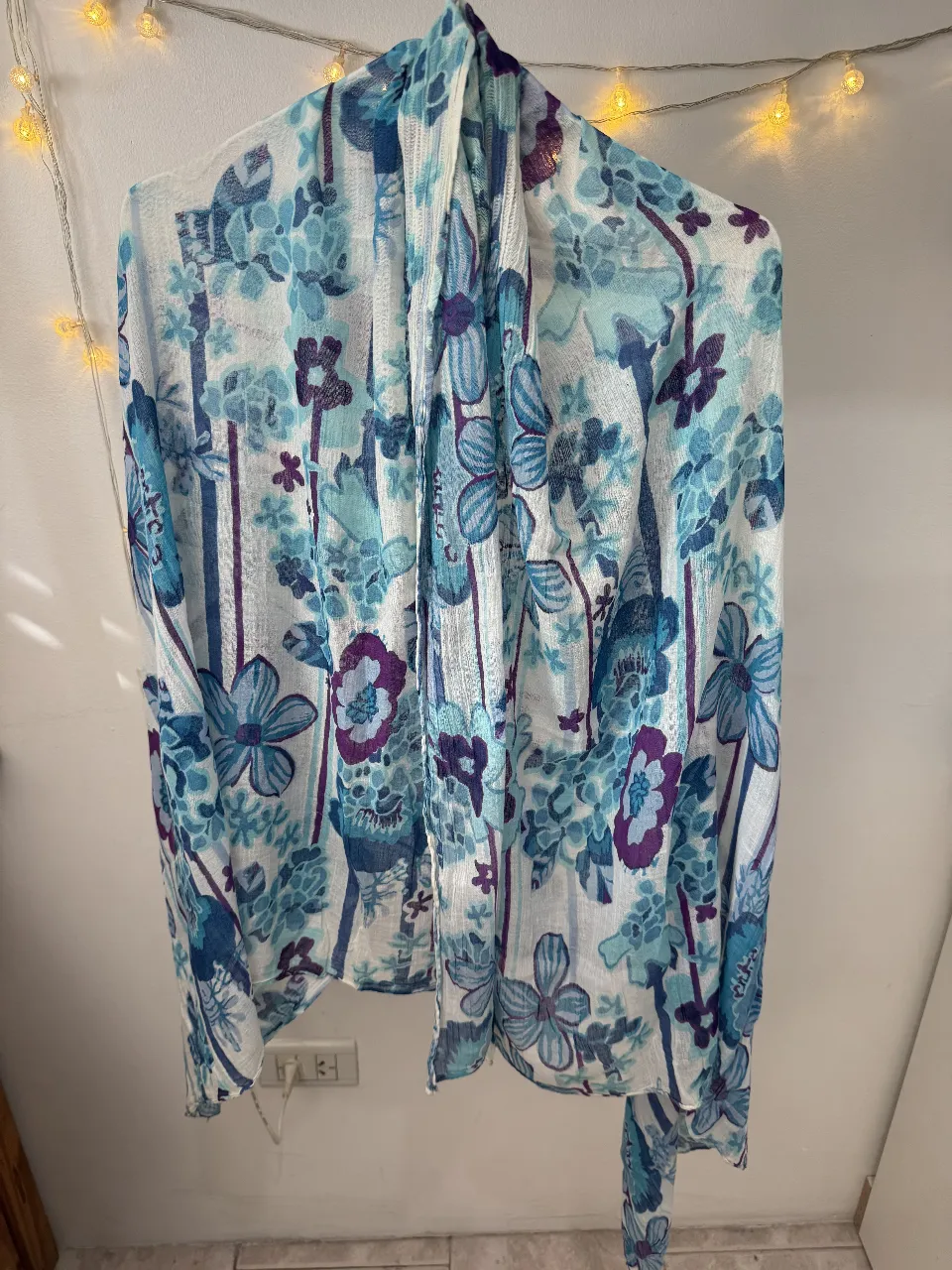 Pañuelo de tela liviana con estampado floral en tonos azules y blancos. Ideal para complementar cualquier look de verano.