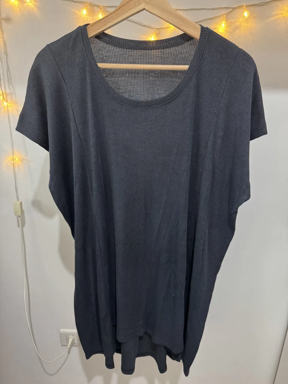 Vestido negro de modal con textura acanalada. Diseño amplio y moderno con mangas cortas y cuello redondo. Ideal para un look casual y cómodo.