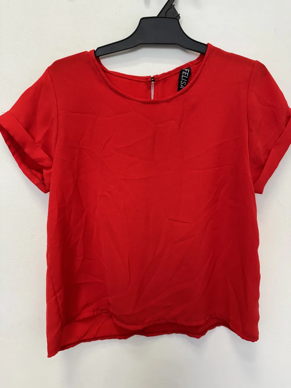 Blusa roja de mujer, con mangas cortas y detalle de cierre en la espalda. Ideal para un look casual y moderno.