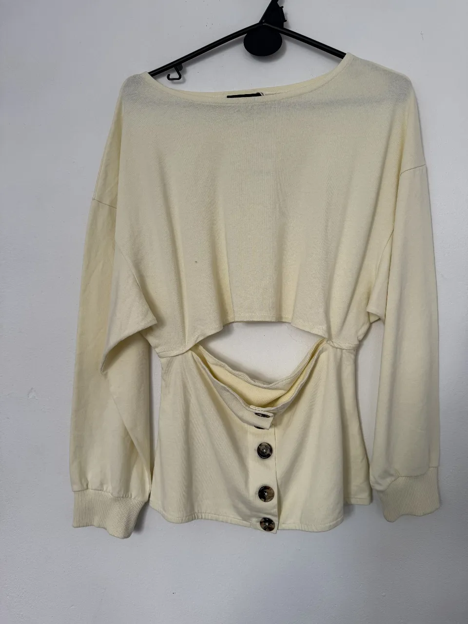 Sweater largo de mujer color crudo con abertura en la cintura y botones decorativos. Ideal para un look casual y moderno.