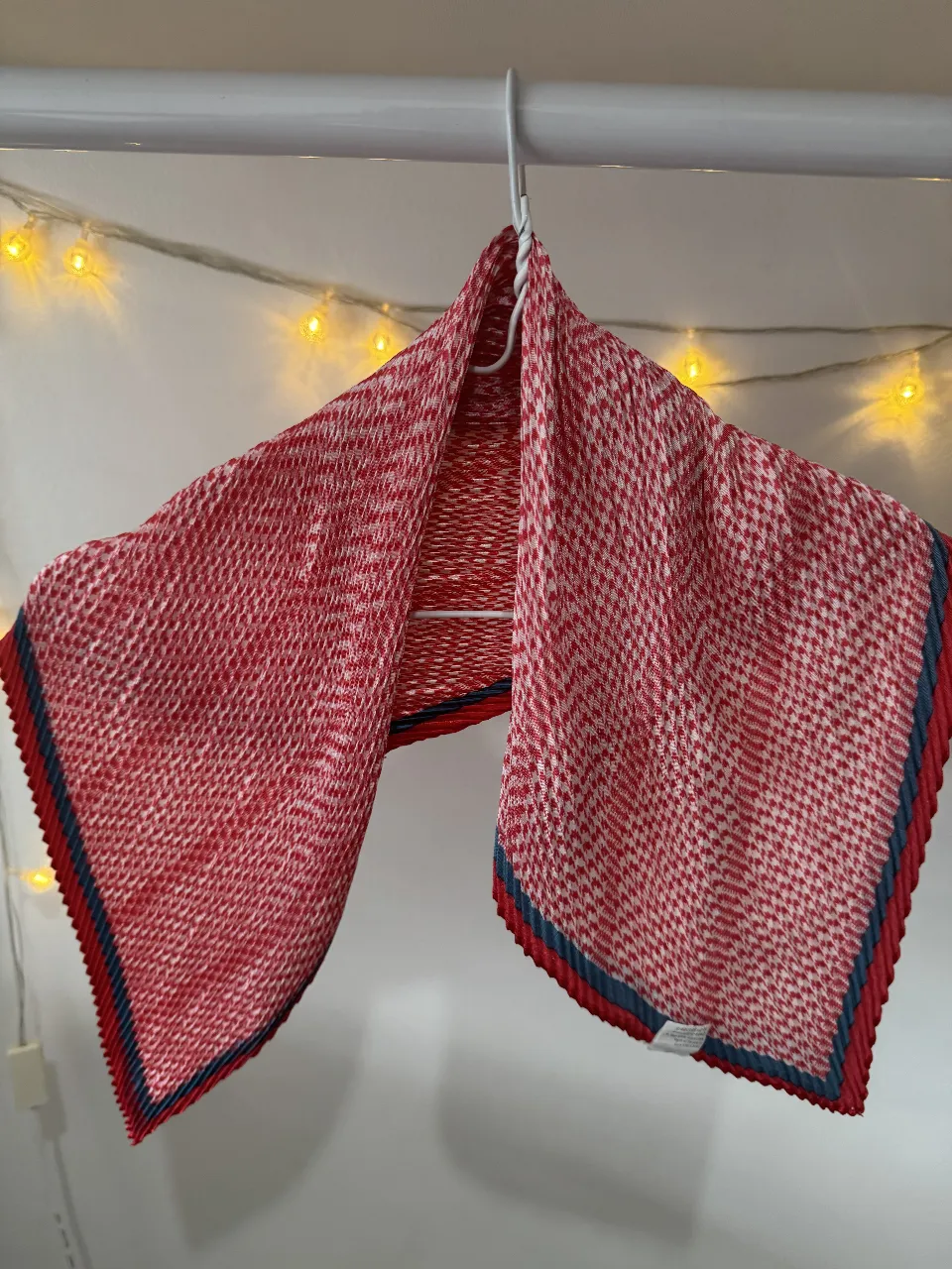 Pañuelo de mujer con estampado de diseño geométrico en rojo y blanco. Detalles en rojo y azul en los bordes. Ideal para complementar cualquier look.
