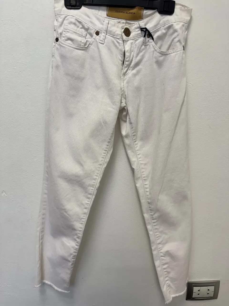 Jeans rectos blancos de mujer, con corte clásico y detalle de flecos en el bajo. Marca Cuesta Blanca.