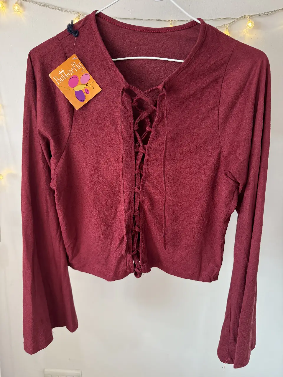 Blusa de manga larga color borgoña con detalle de lazada en el frente. Ideal para un look casual y moderno.