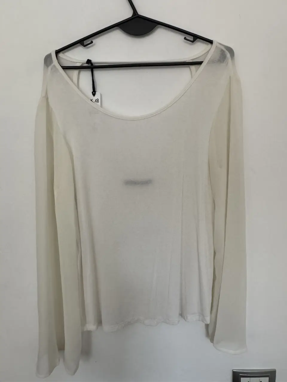Blusa de manga larga color blanco, con escote redondo y detalle de abertura en la espalda. Ideal para un look casual y elegante.