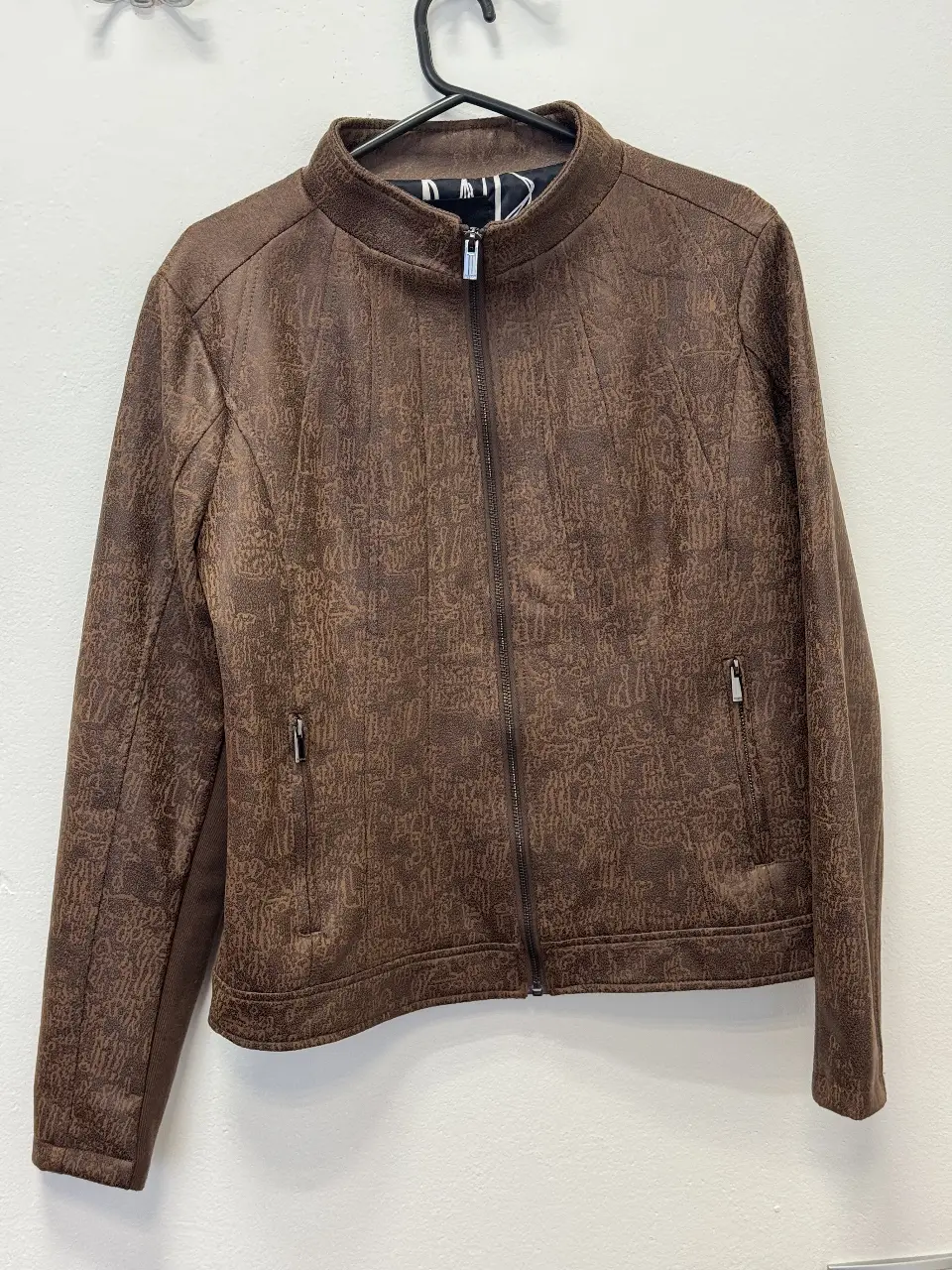 Campera de mujer estilo biker en color marrón con textura. Posee cierre y bolsillos con cremallera. Talle 40.