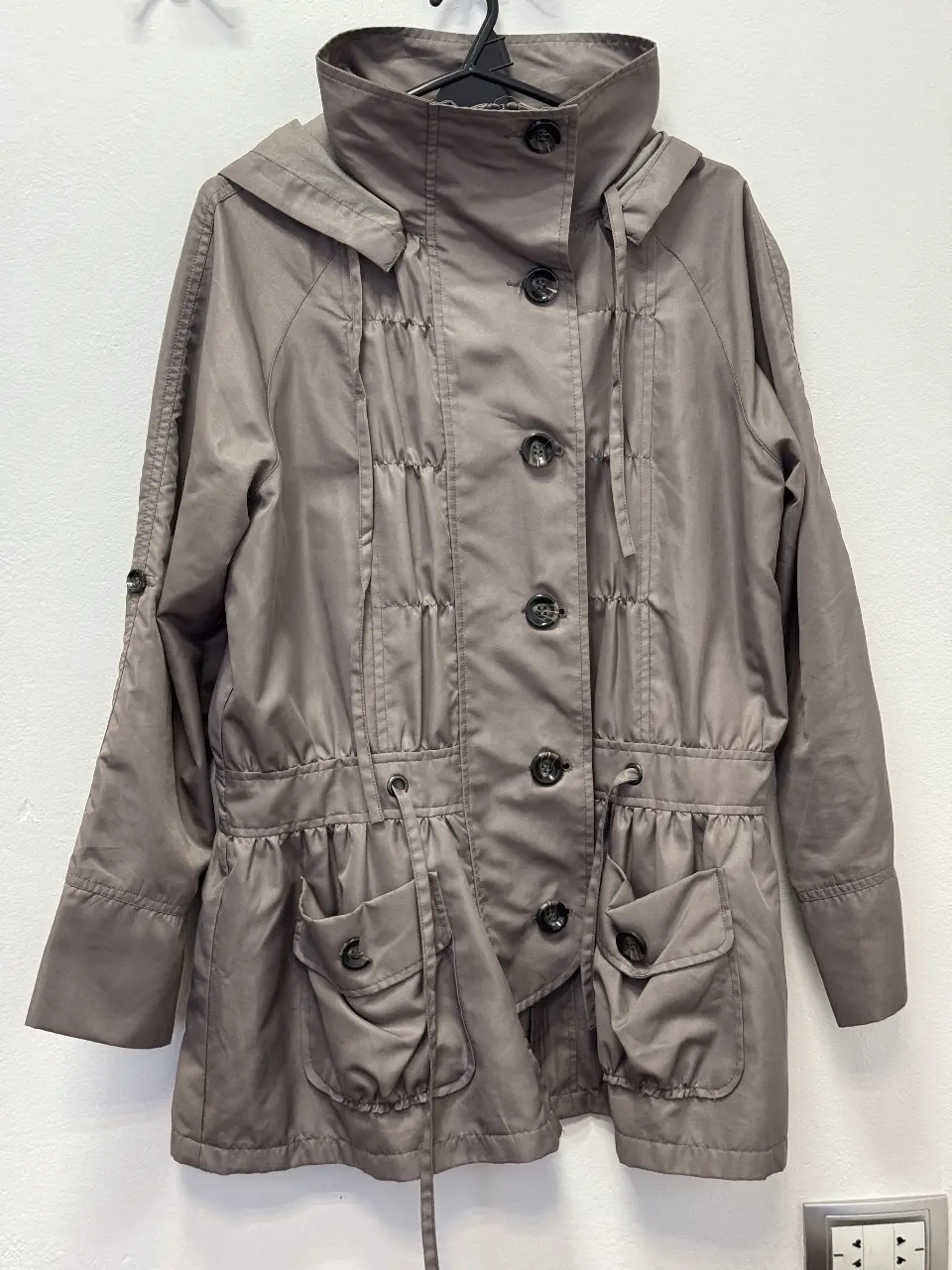 Campera gris con capucha y botones, estilo utilitario. Ideal para el día a día.
