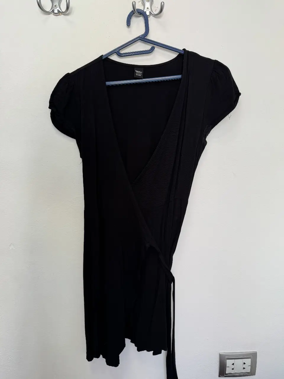 Vestido negro corto, con mangas cortas abullonadas y escote en V. Ideal para una salida o evento semi-formal.