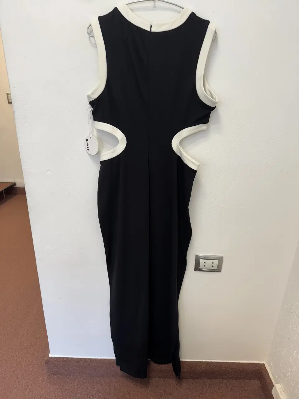 Vestido midi negro con detalles en blanco y aberturas laterales. Ideal para una fiesta o evento especial. Diseño elegante y moderno.