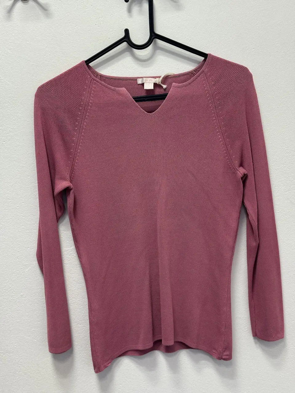 Sweater de mujer en color rosa, con cuello en V y mangas largas. Ideal para un look casual y cómodo.