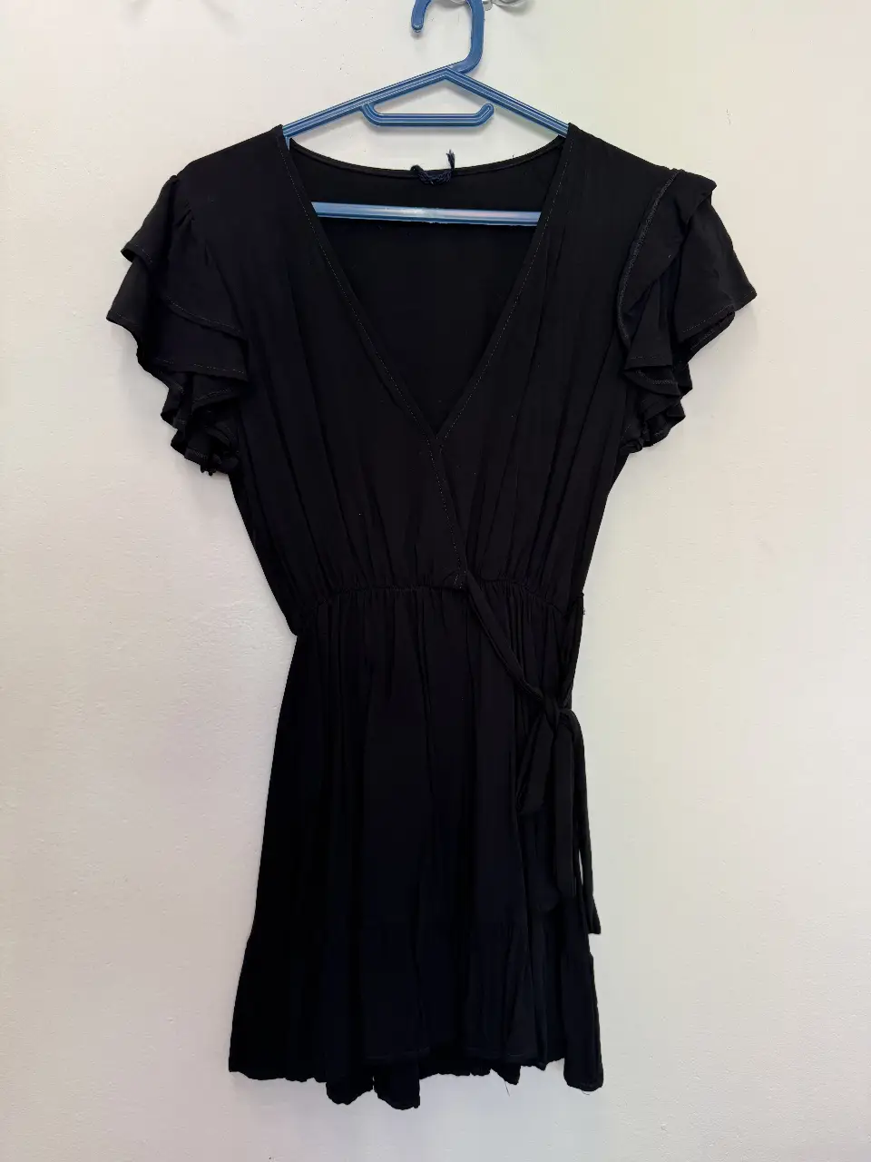 Vestido negro corto con mangas cortas con volados y detalle de lazo en la cintura. Ideal para una salida o evento especial.