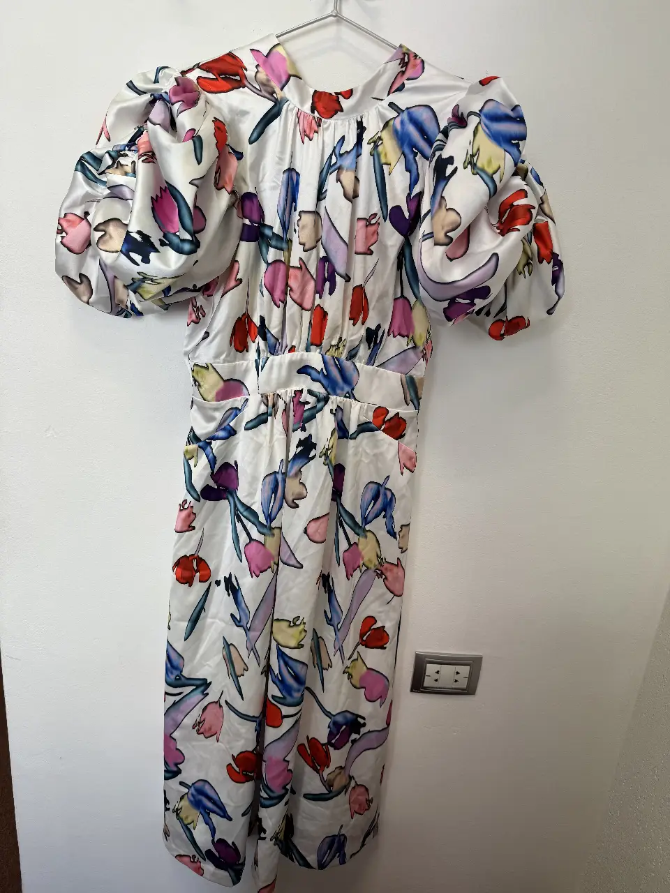 Vestido midi con estampado floral en tonos vibrantes. Diseño con mangas abullonadas y espalda descubierta con lazos. Ideal para eventos especiales o salidas de verano.