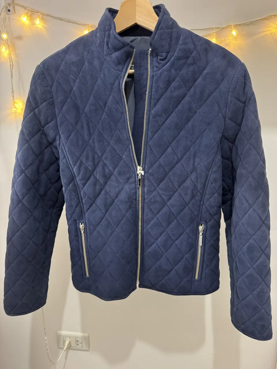 Campera azul de gamuza con diseño de rombos. Tiene cierre y bolsillos con cierre. Marca Lopez Taibo.