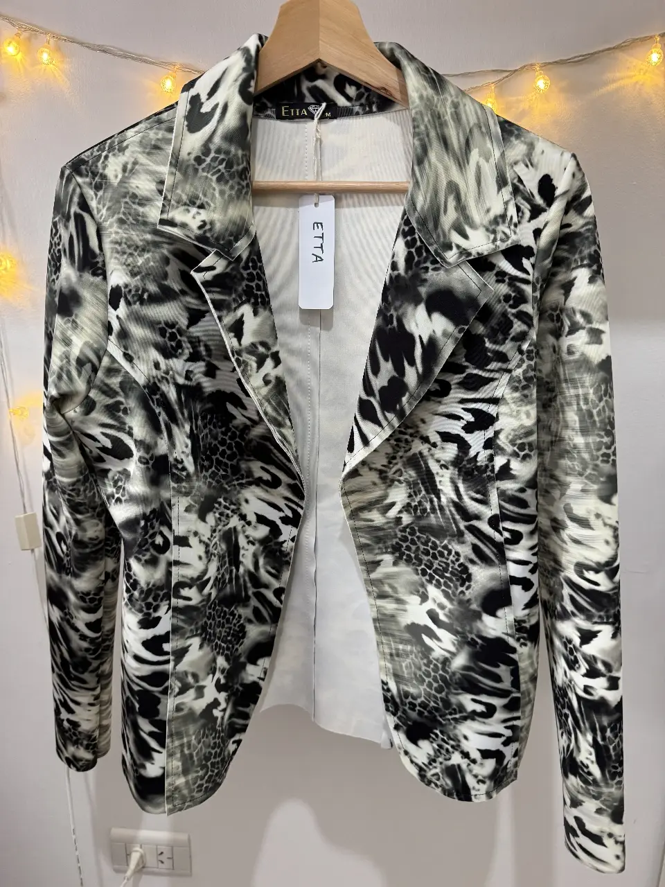 Elegante blazer con estampado animal print en blanco y negro. Ideal para un look sofisticado y moderno. Marca Etta, talle M.