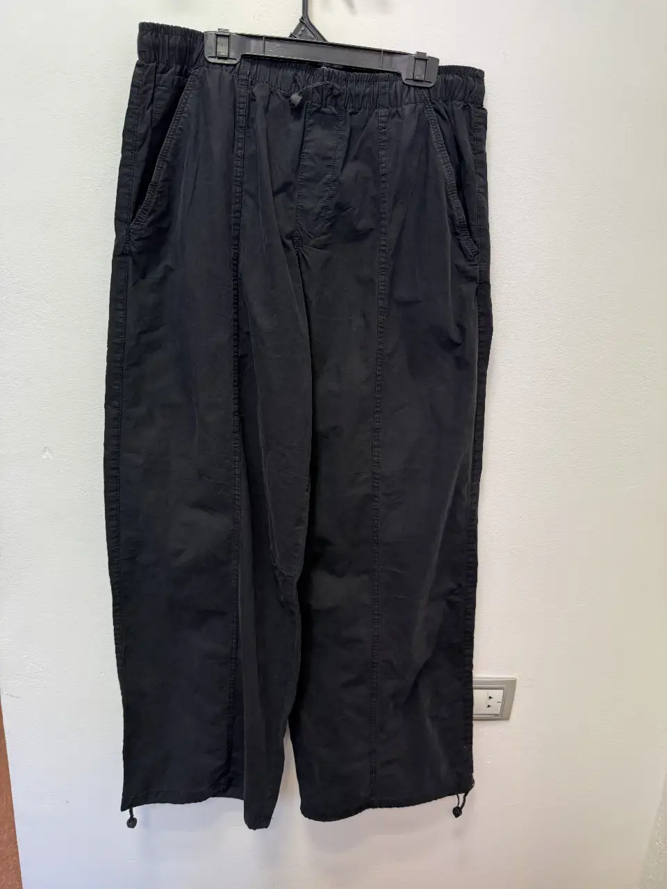 Pantalón negro suelto de hombre, con cintura elastizada y costuras marcadas. Ideal para un look casual y cómodo.