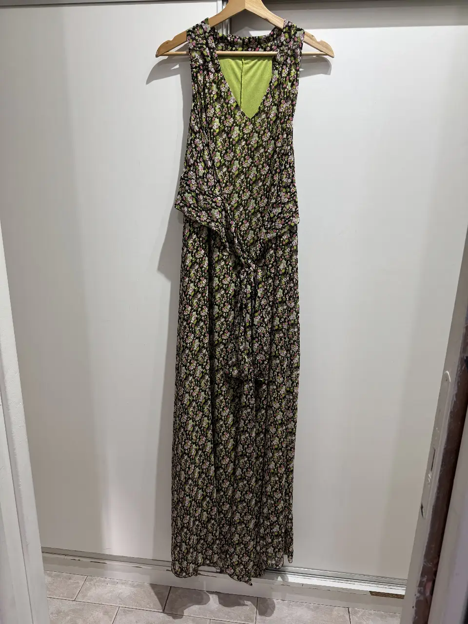 Vestido largo de mujer con estampado floral en tonos negro, rosa y verde. Tiene un diseño con escote en V y un detalle anudado en la cintura. La tela es ligera y fluida, ideal para el verano. La marca es Lovissa.