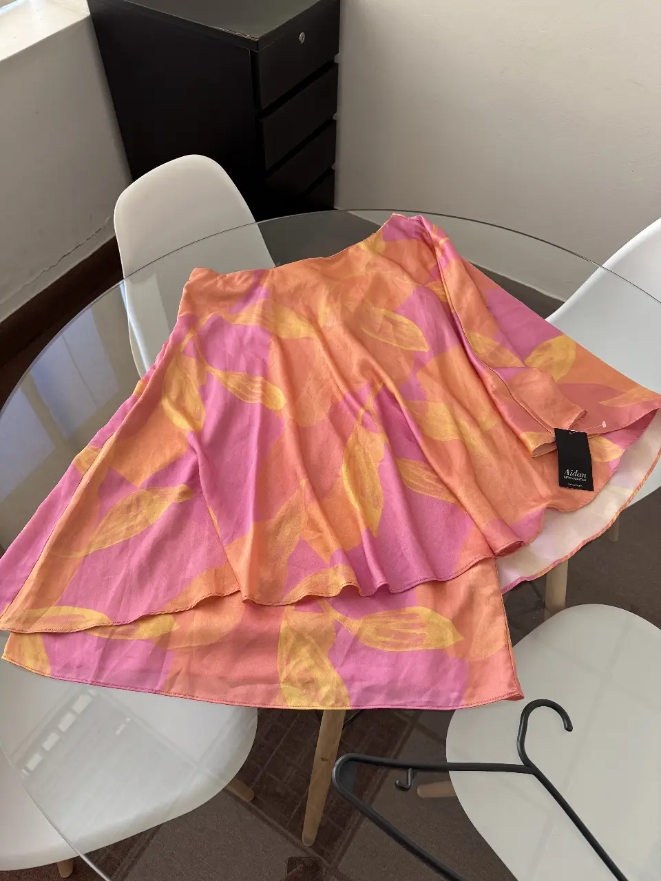 Blusa  asimétrica de la marca Aidan Mattox, con estampado floral en tonos rosa y naranja. Ideal para un look de fiesta o salida, con un solo hombro