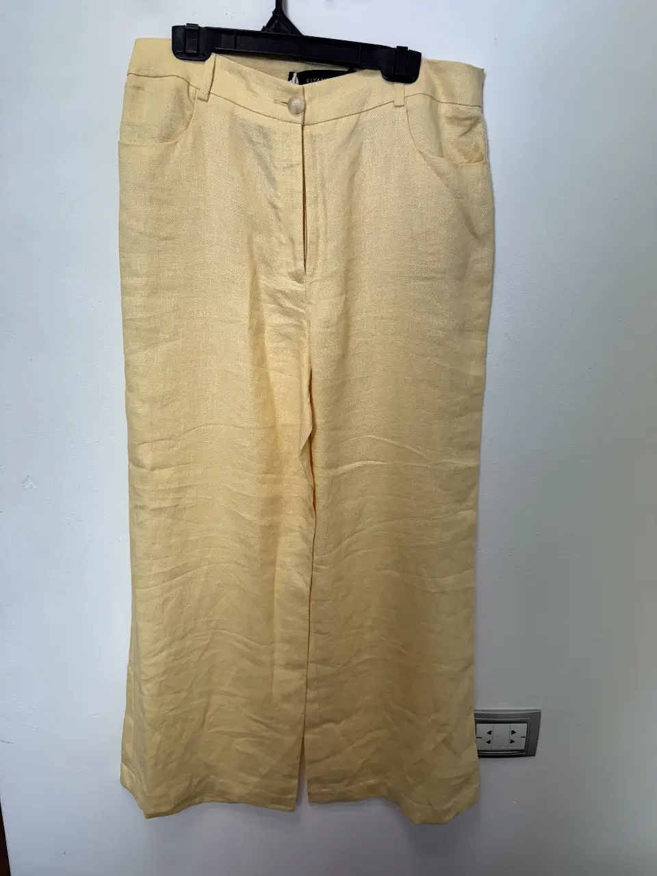 Pantalón sastrero de lino amarillo, tiro medio, corte recto y bolsillos delanteros. Ideal para un look fresco y elegante.
