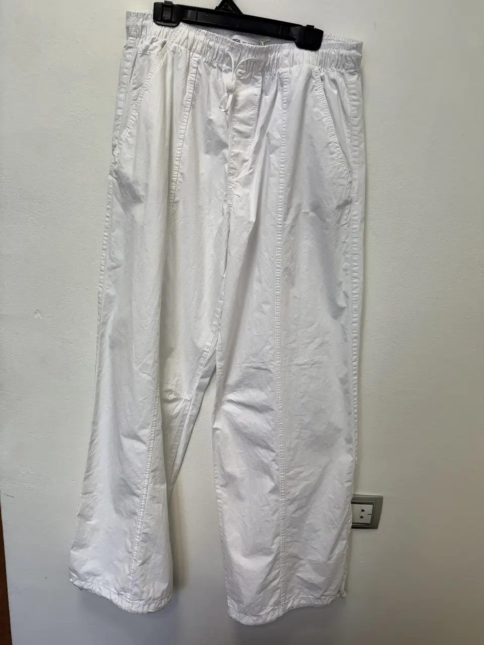 Pantalón blanco suelto de tela liviana, con cintura elastizada y cordón ajustable. Ideal para un look casual y cómodo.