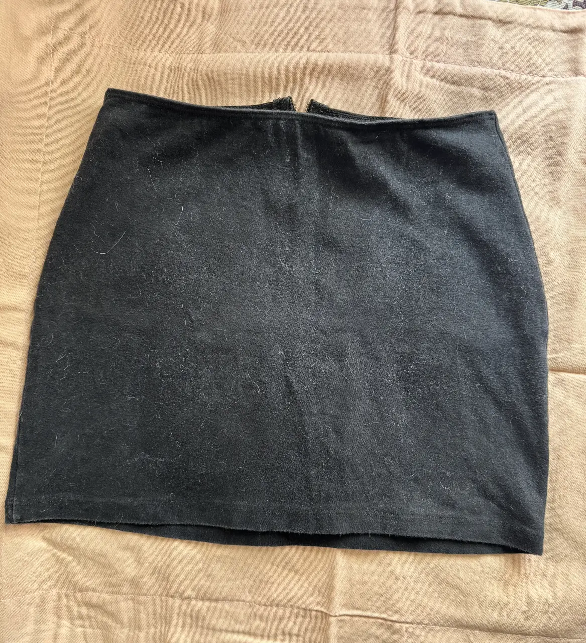 Minifalda negra con cierre en la parte trasera. Ideal para un look casual y versátil.