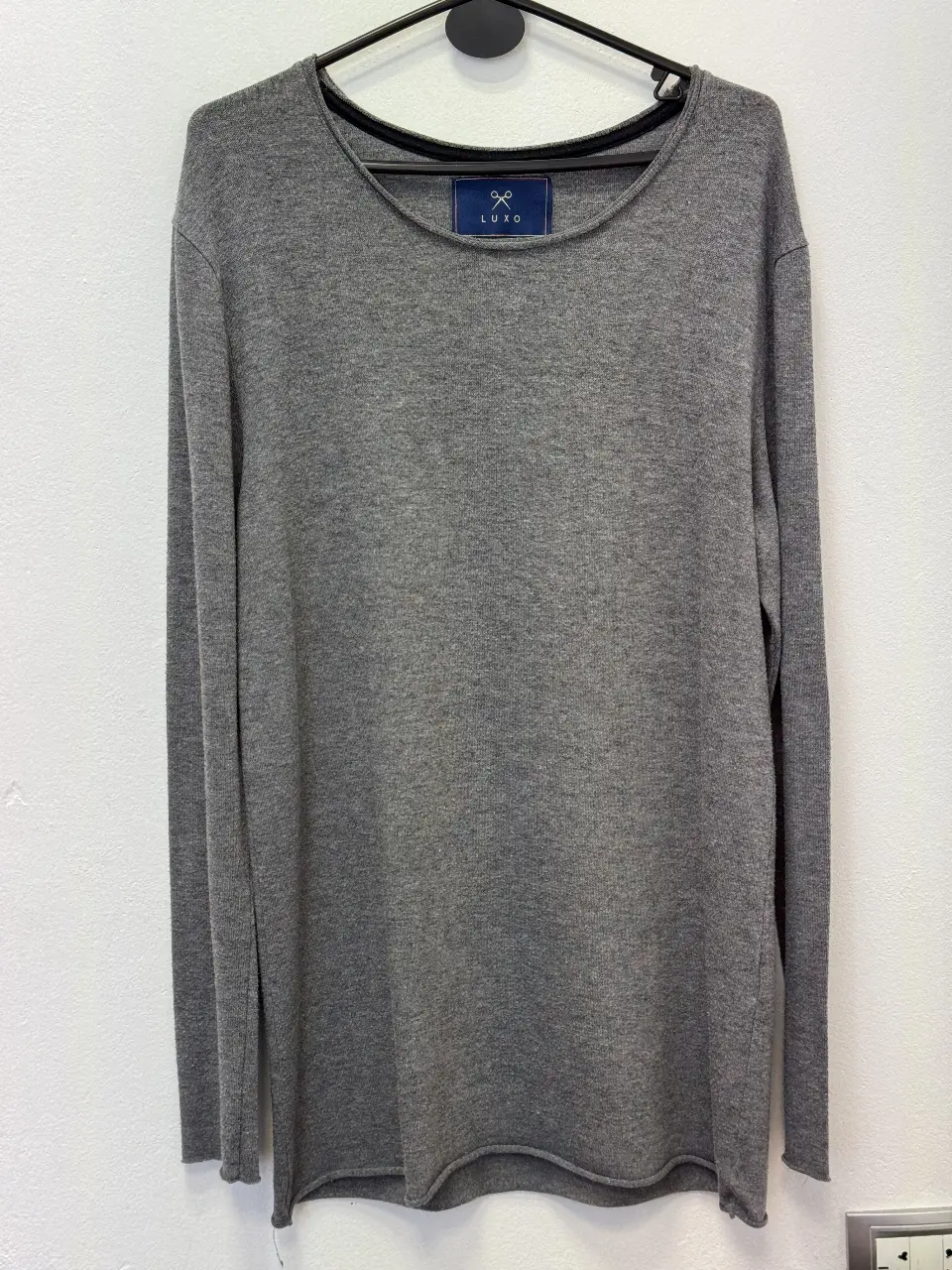 Sweater gris de manga larga, cuello redondo y talle medium. Ideal para un look casual y cómodo.