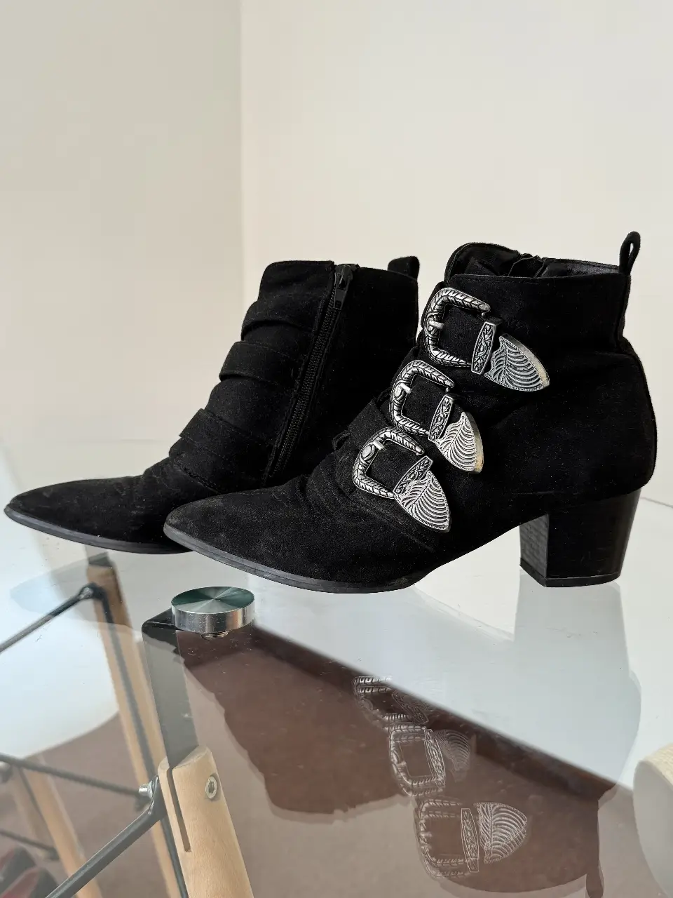 Botines negros de gamuza con detalles plateados y hebillas. Ideales para un look rocker o casual.