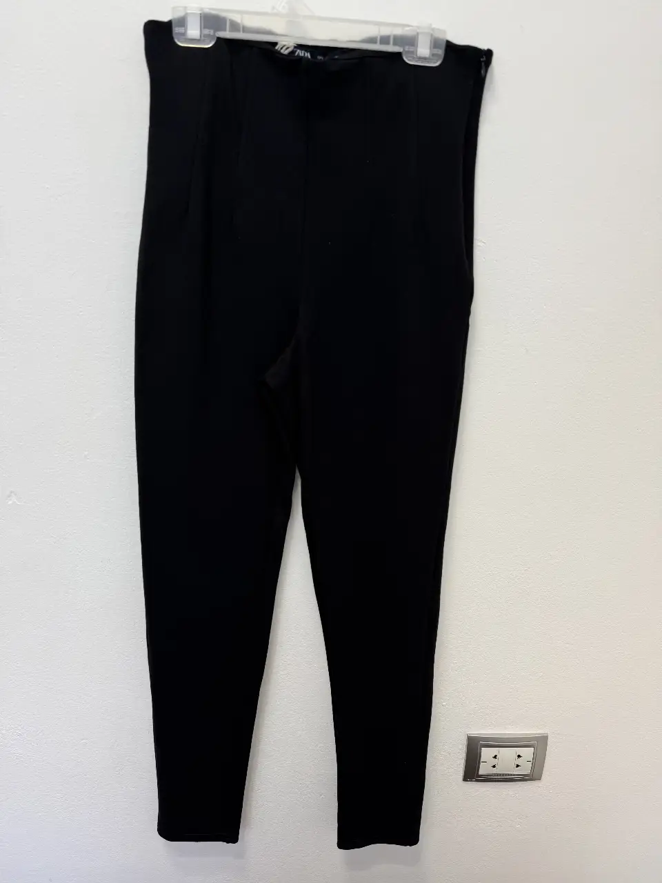 Pantalón sastrero negro de mujer, tiro alto, con cierre lateral y etiqueta de la marca Zara. Talle L.