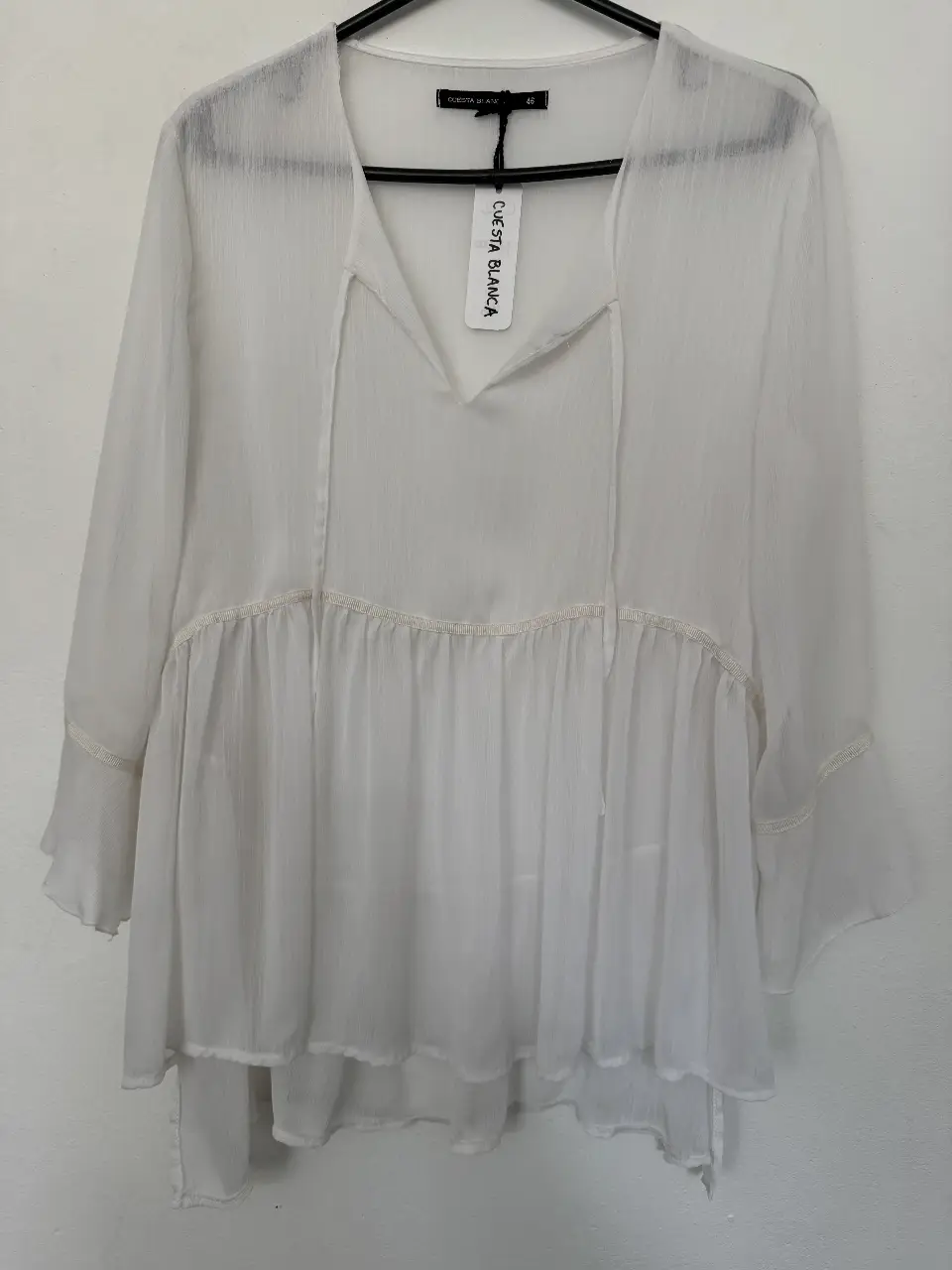 Blusa blanca de gasa con detalle de volados y mangas amplias. Ideal para un look fresco y elegante.