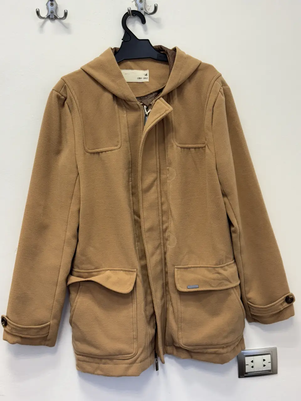 Tapado de paño color marrón con capucha, estilo duffle coat. Tiene bolsillos delanteros amplios y botones en las mangas. Ideal para el invierno.