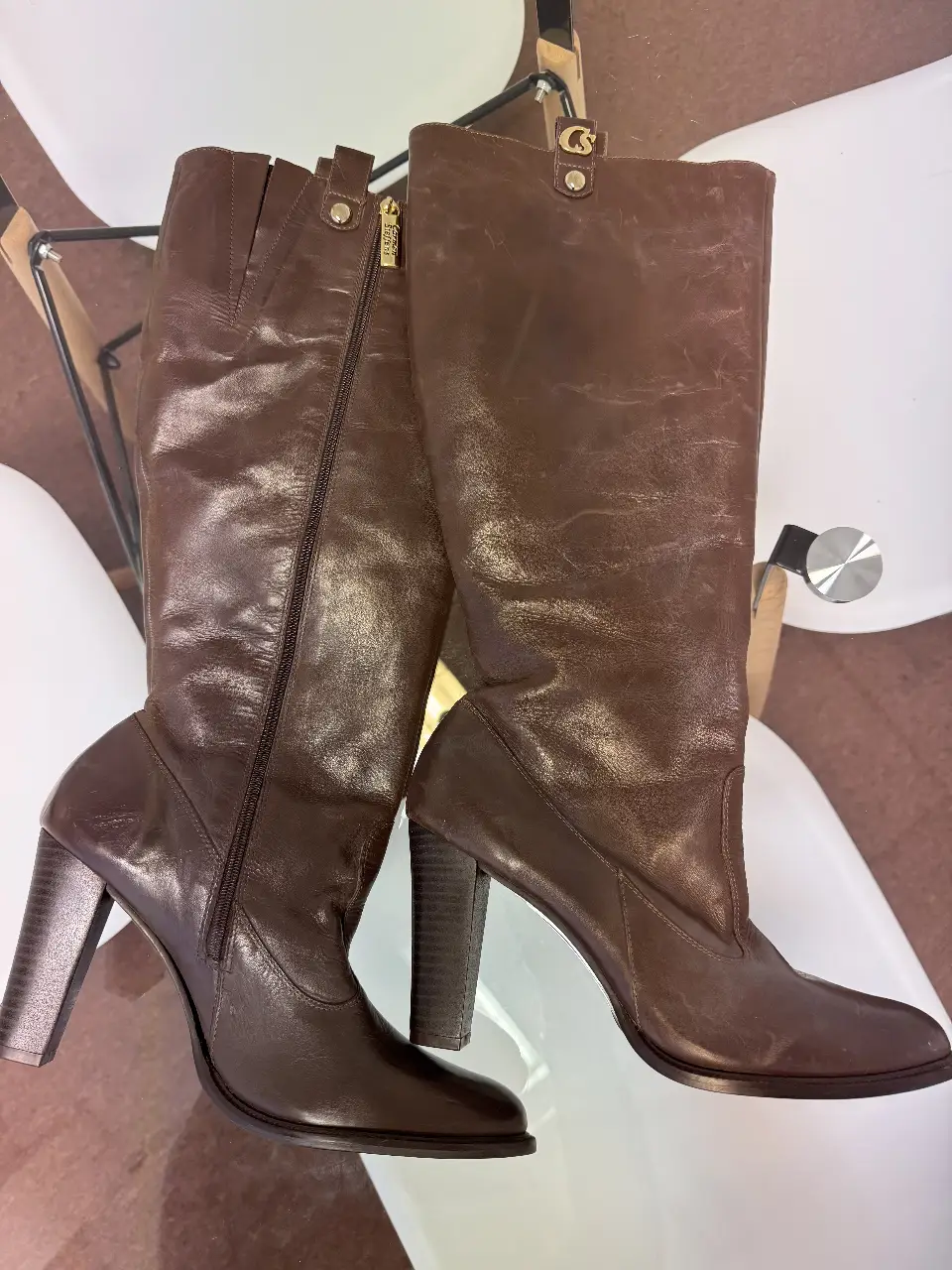 Botas de caña alta de cuero marrón con taco alto. Interior con estampado animal print. Cierre lateral con detalle de cremallera dorada y logo de la marca. Talle 42.