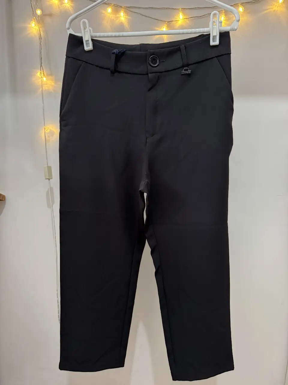 Pantalón sastrero negro de corte recto, con detalles de diseño como un botón y la marca "ST. MARIE". Ideal para un look formal o de trabajo.