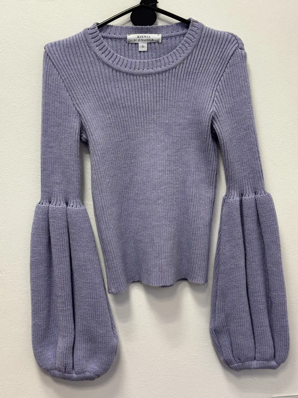 Sweater de punto morado con mangas abullonadas. Ideal para un look moderno y sofisticado.