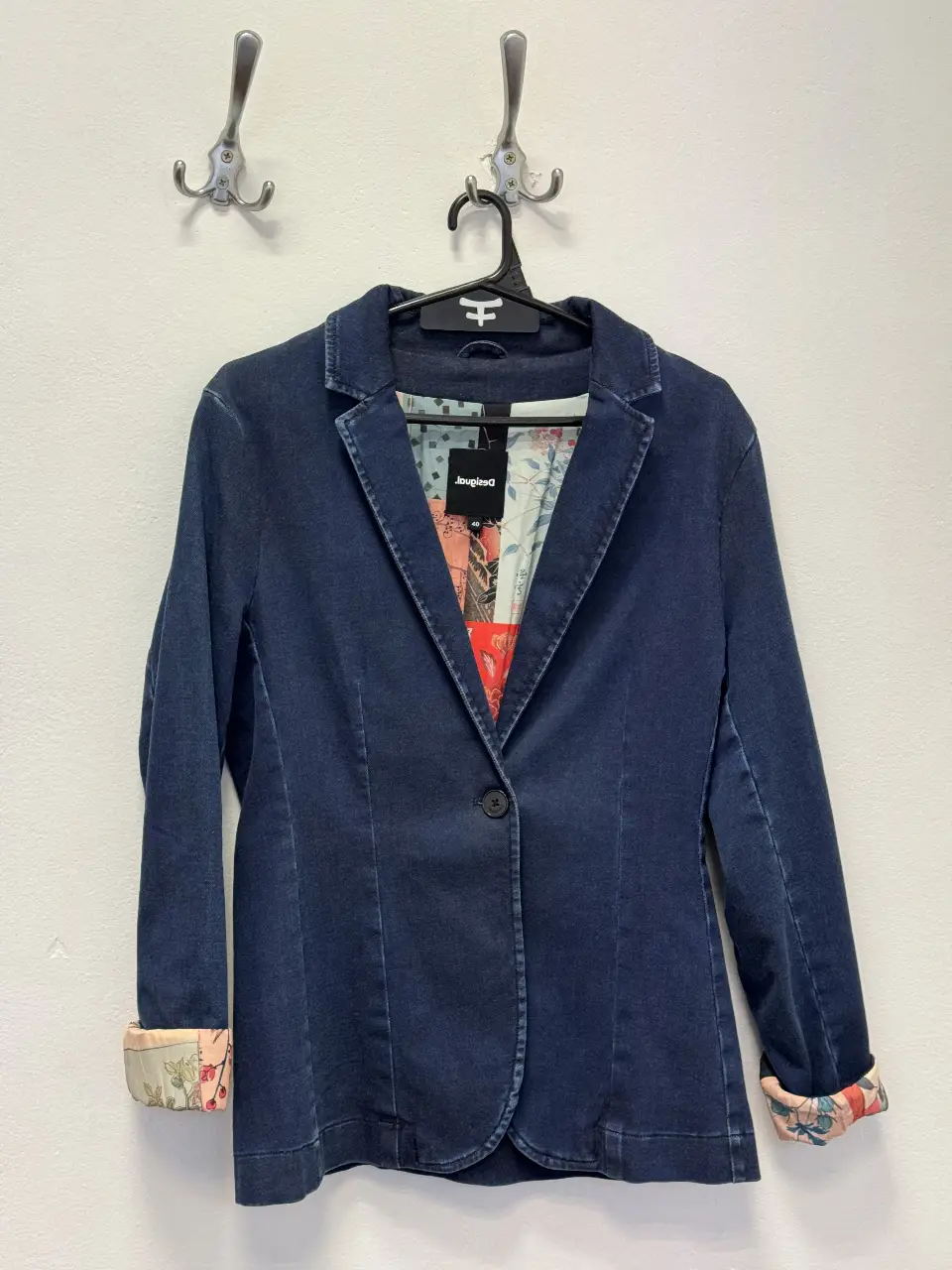 Blazer de jean azul oscuro de mujer, con forro interior estampado y detalles en los puños. Ideal para un look casual y moderno.