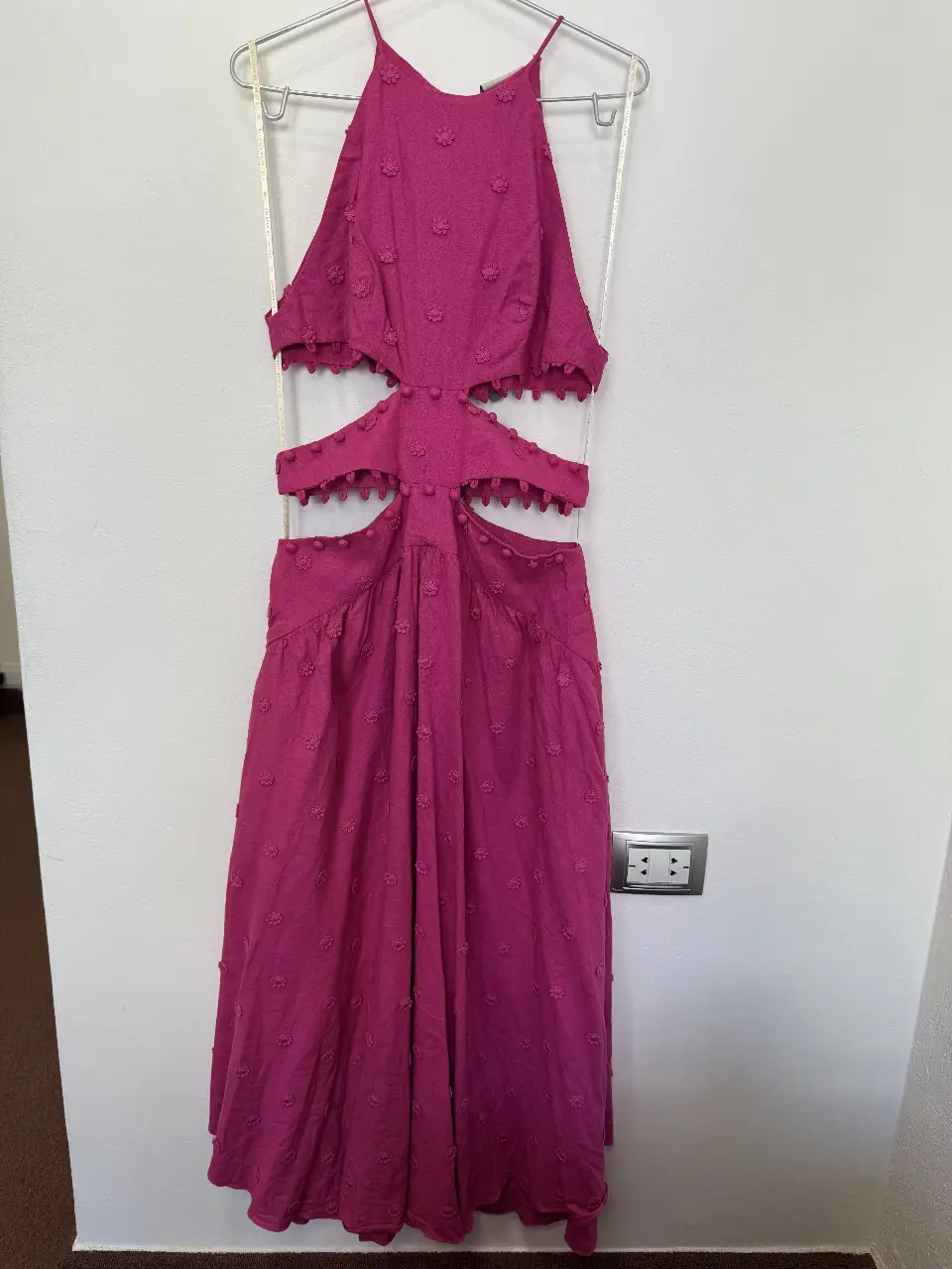 Vestido midi fucsia con aberturas laterales y detalles florales en relieve. Ideal para un look fresco y moderno.