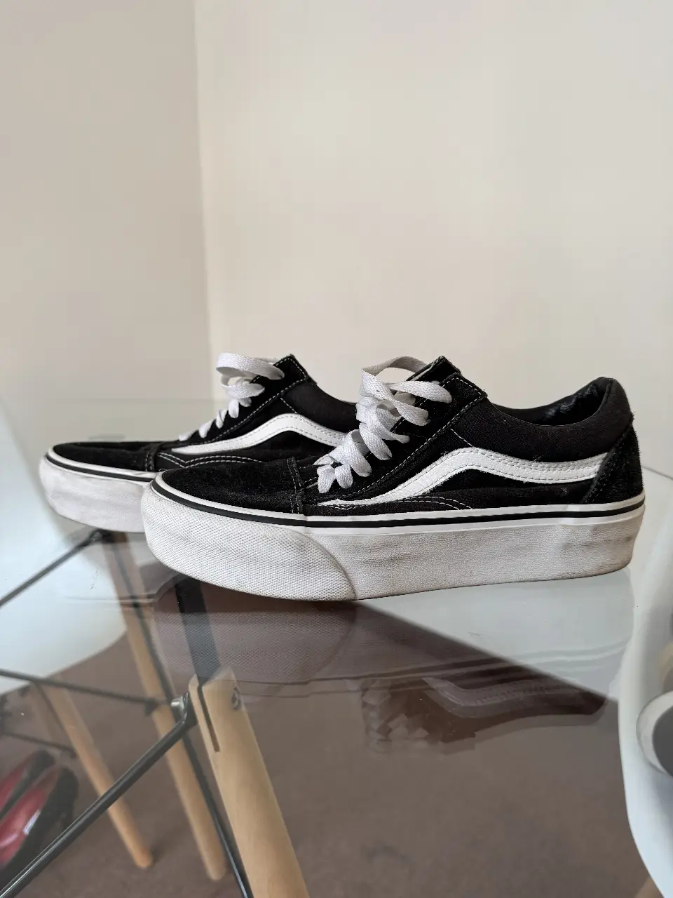 Zapatillas Vans Old Skool con plataforma, negras con la icónica franja blanca. Tienen cordones blancos y suela blanca. Ideales para un look urbano y cómodo.