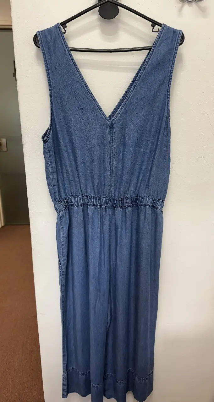 Mono largo de jean azul, con cintura elastizada y escote en V. Ideal para un look casual y cómodo.