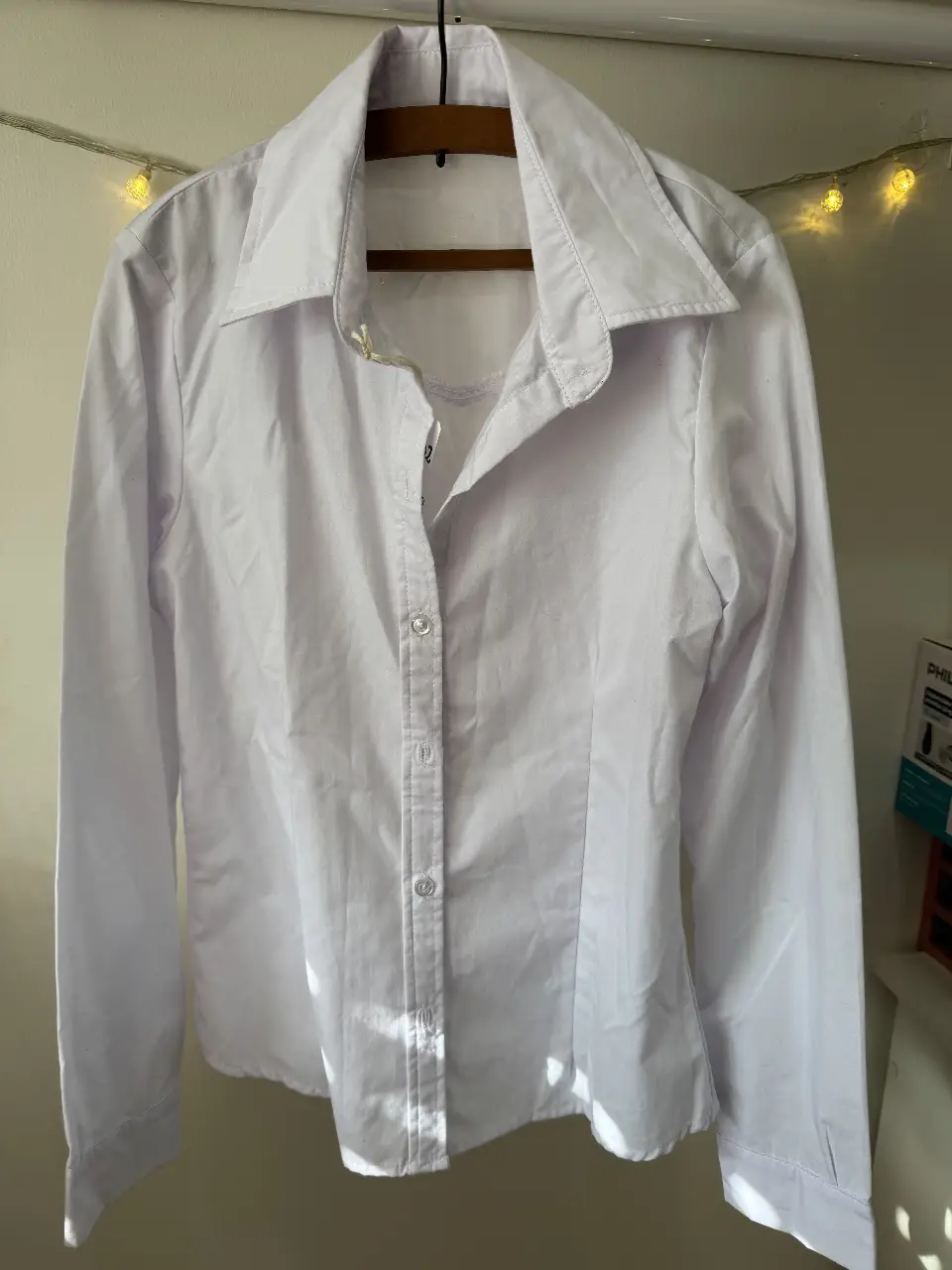 Camisa blanca de manga larga con cuello clásico, ideal para un look formal o casual. Confeccionada en tela suave y cómoda, perfecta para combinar con diferentes outfits.