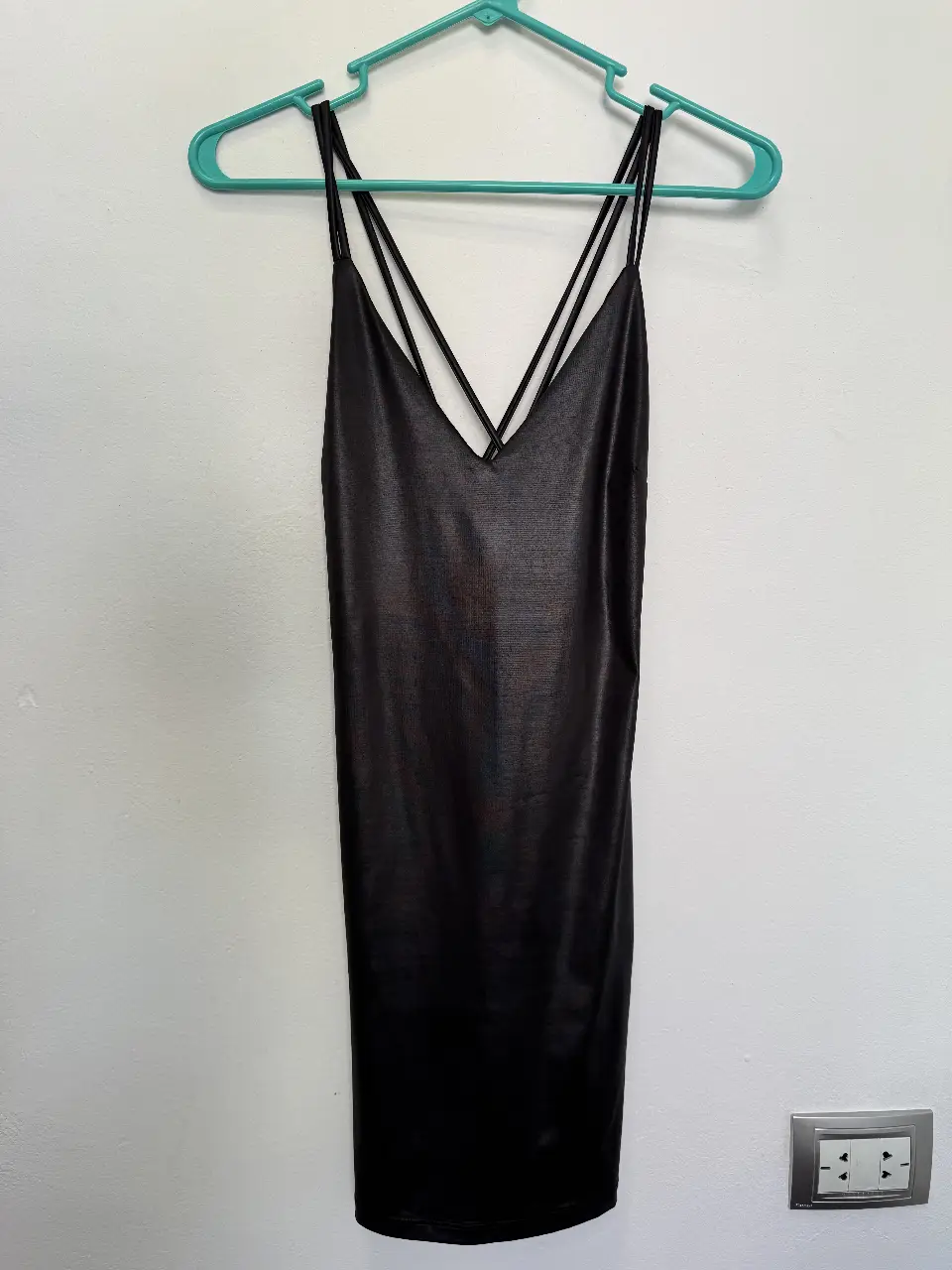 Vestido mini negro con tiras finas cruzadas en la espalda y escote en V. Ideal para una salida nocturna o evento especial.