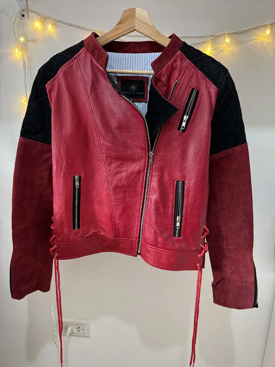 Campera biker de cuero roja con detalles en negro y detalles de cordones. Ideal para un look rocker y audaz.