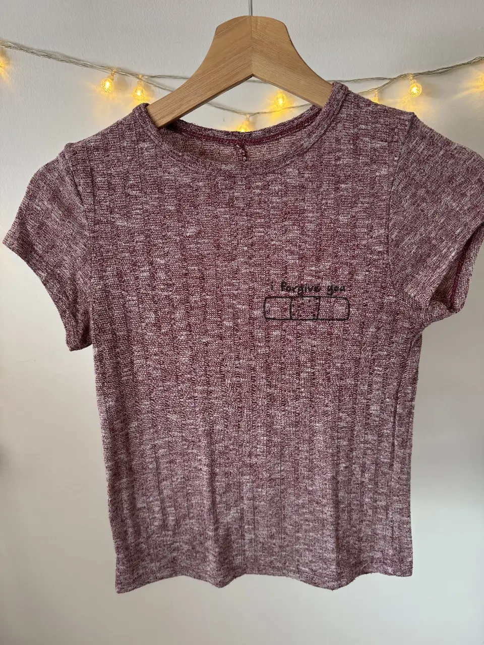 Remera de manga corta para mujer, de color bordó con detalle de estampado en el frente. Ideal para un look casual y cómodo.