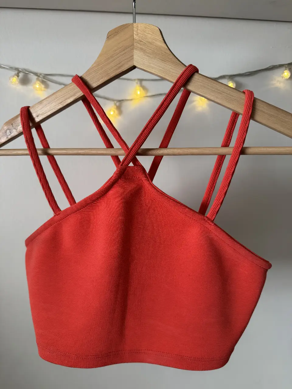 Top crop con tiras cruzadas en la espalda, ideal para un look moderno y audaz. Perfecto para combinar con jeans de tiro alto o una falda.